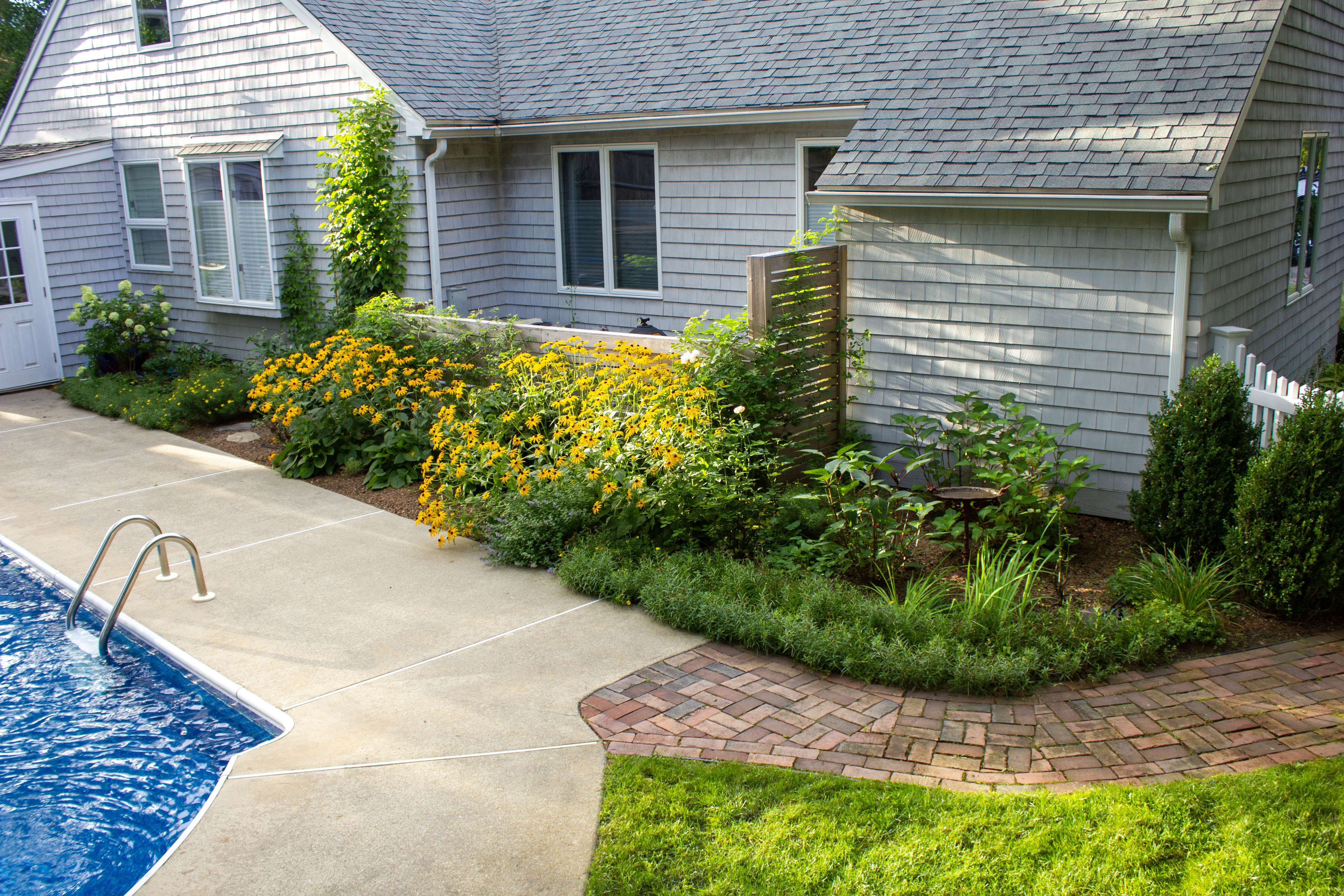 Custom design in Newburyport Ma poolside garden with brick patio and perennials 