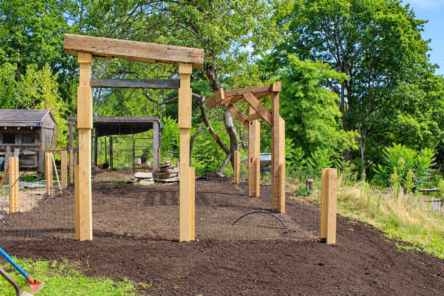 Custom timber garden arbor and wire fencing installation surrounded by mature greenery, built by JMJ Gardens for a functional and natural outdoor space.