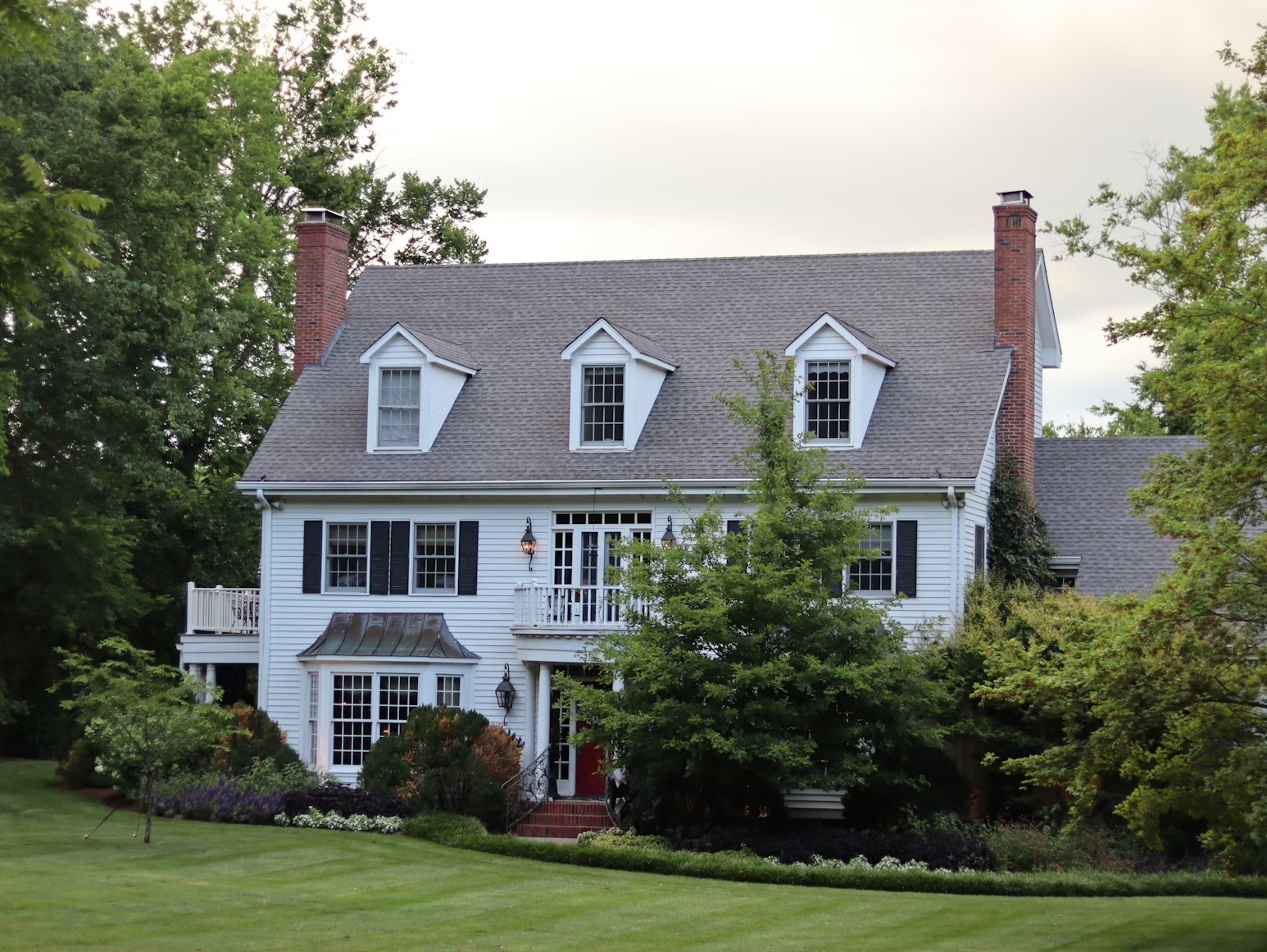 Victorian modern home Andover ma with evergreen trees and border garden, front yard with green lawn