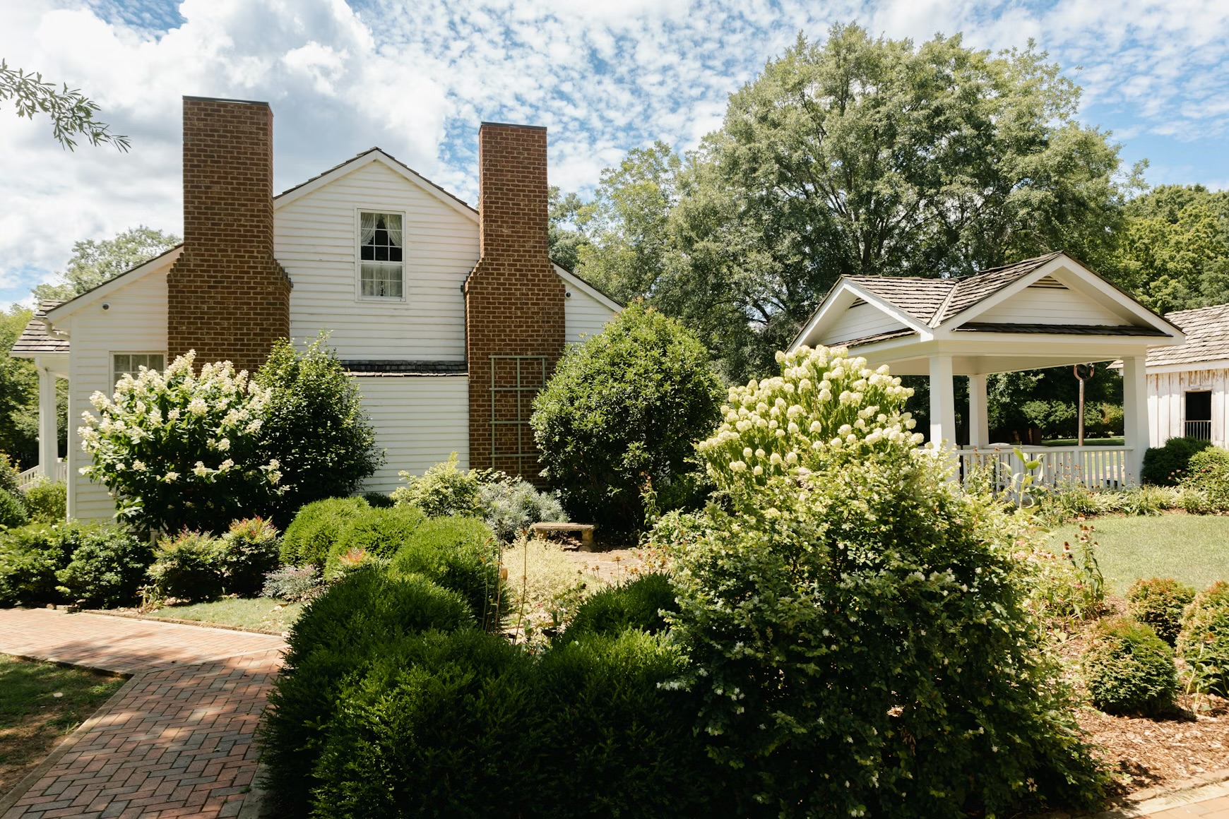 Newburyport ma home with hydrangea shrubs and perennials White House with brick lawn and garden