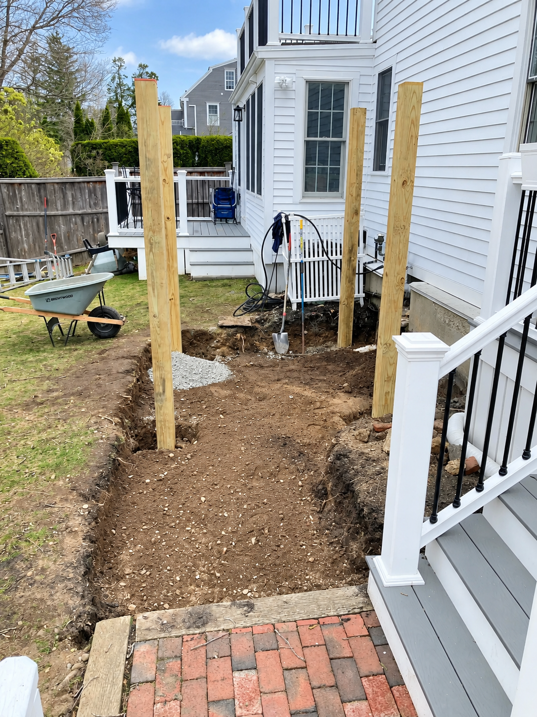Pressure-treated wood posts installed beside a home during the early stages of a custom pergola and patio construction project.